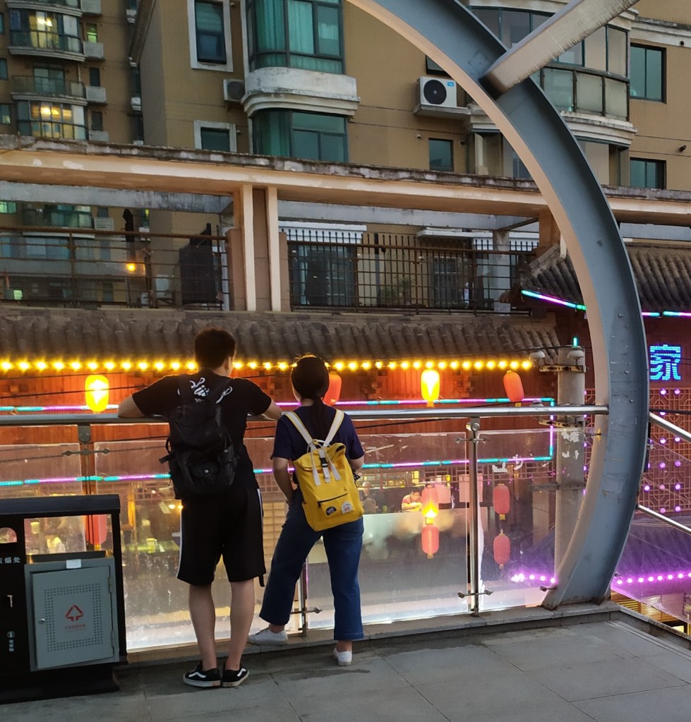A photo of a couple standing on a bridge in Wuhan, China in 2019.