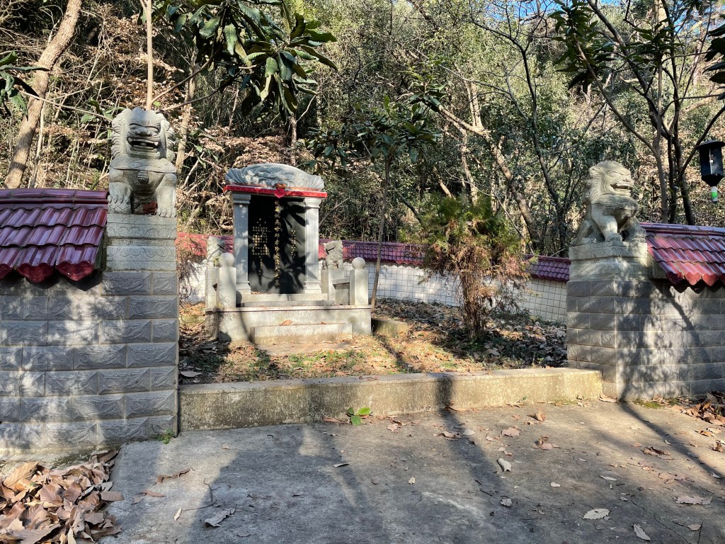 This photo shows a tomb in Wuhan, China with stone lion "foo dogs" standing guard around it.