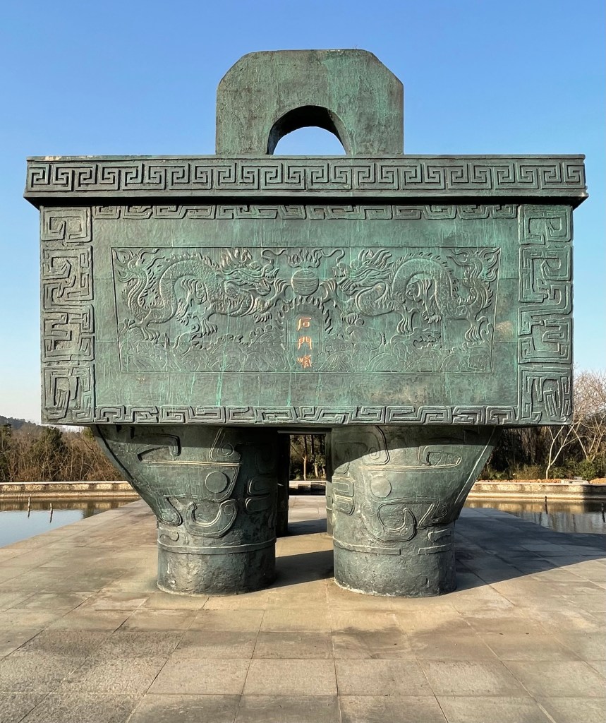 This is a photo of a mock giant Chinese bronze. It sits in Shimenfeng Memorial Park in Wuhan, PRC. The photo was taken in 2021.