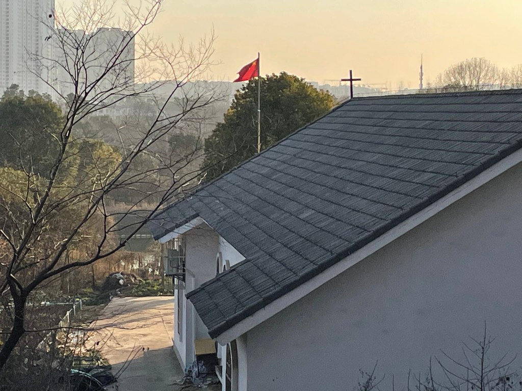 This is a photo of a church in Hongshan, Wuhan, China. It is probably part of the Three Self Church denomination. A PRC flag flies in front of it. Taken in January, 2021.