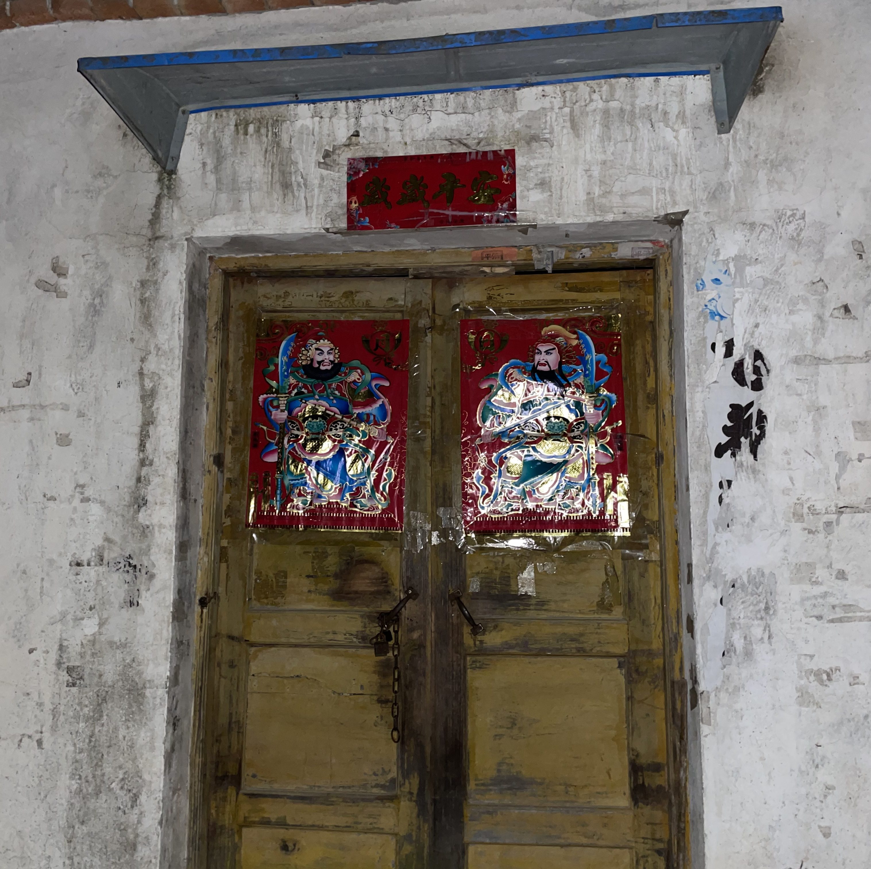 This is a photo of a door in Hubei, China in 2021. On the door, there are two traditional door gods.
