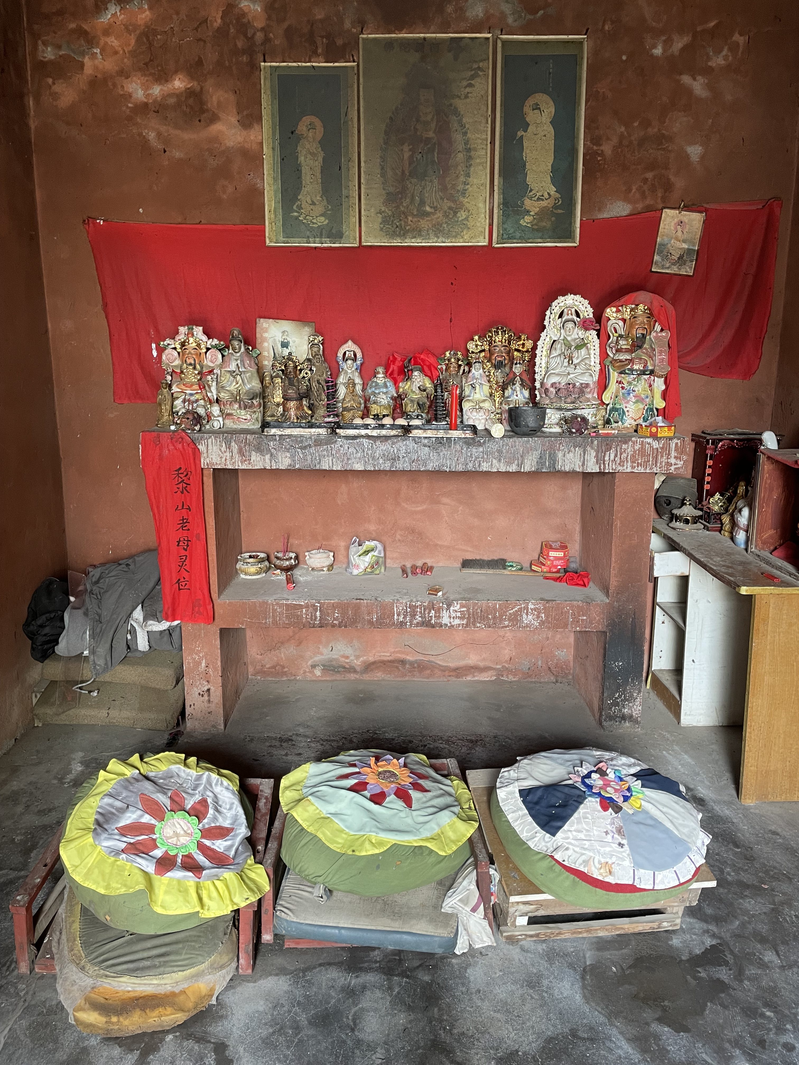 This is a photo of an alter with many idols. Some of the deities represented include Guanyin (Bodhisattva), Guanyu (ancestral deity, god of war), Caishen the money god, and the earth god.