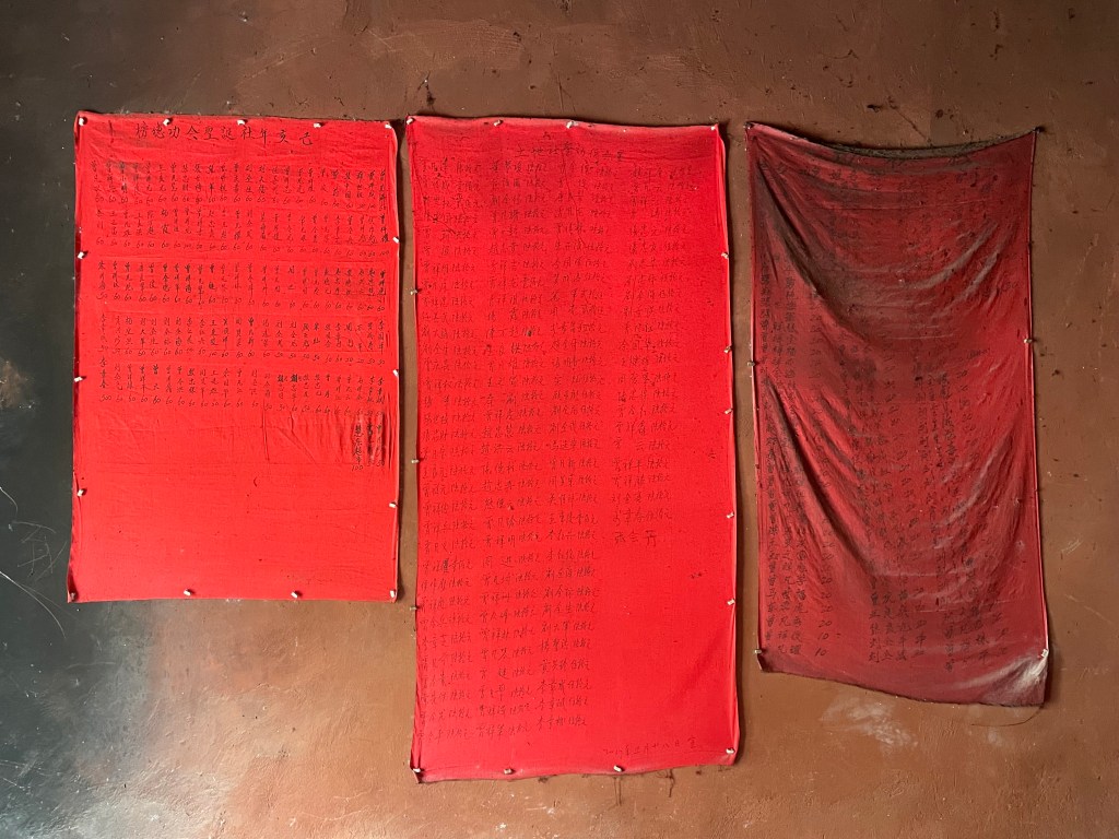 This photo depicts the names of donors to a small temple in China written on a red cloth (2021).