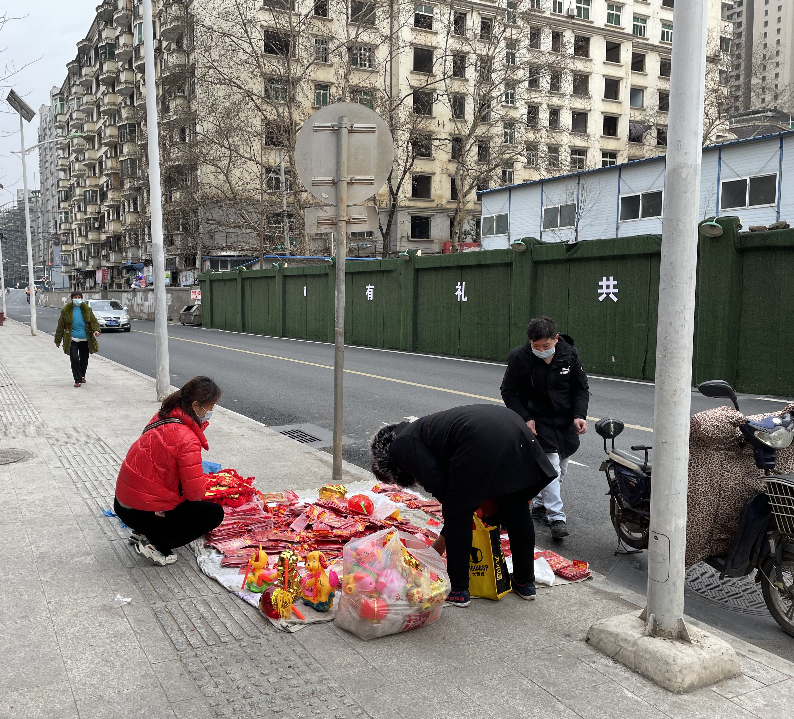 This is a photo of a woman selling Spring Festival items on a street blanket in Wuhan in 2021.