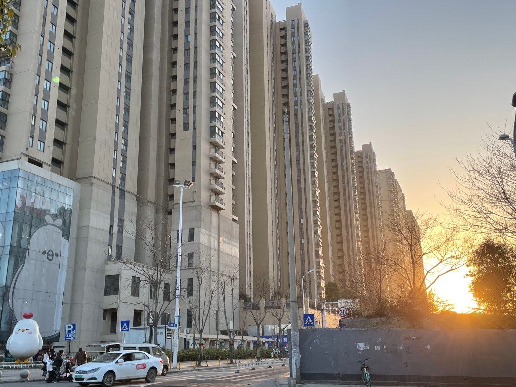 This is a photo of a sunset in Wuhan, and in the foreground is a line of apartment towers. 2021.